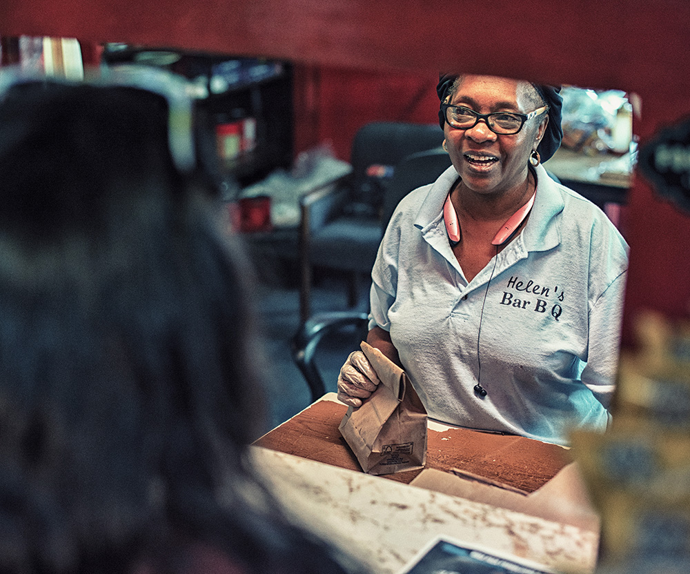 A woman serves a meal at Helen's BBQ restaurant in Brownsville, TN.